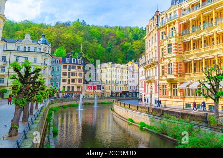 Karlovy Vary, République tchèque, 11 mai 2019 : les gens descendent la rue et le quai de la rivière Tepla dans le centre-ville historique de Carlsbad avec de beaux bâtiments traditionnels colorés, la Bohême de l'Ouest Banque D'Images