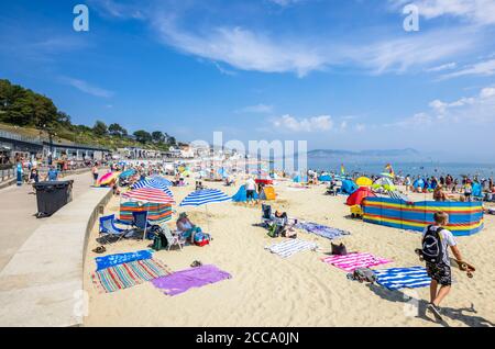 La plage bondée et le front de mer en haute saison à Lyme Regis, une station balnéaire populaire sur la côte jurassique à Dorset, au sud-ouest de l'Angleterre Banque D'Images