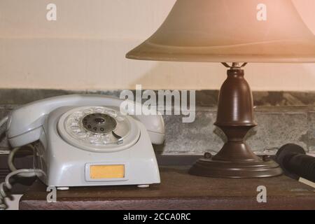 Téléphone gris ancien et lampe rétro sur le concept de bureau image Banque D'Images