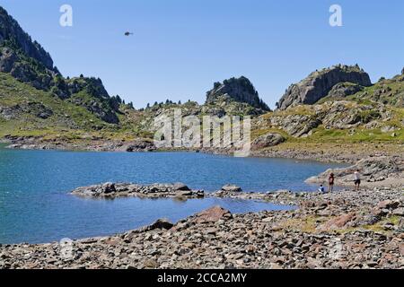 Un hélicoptère dans le ciel d'un lac de montagne bleu Banque D'Images