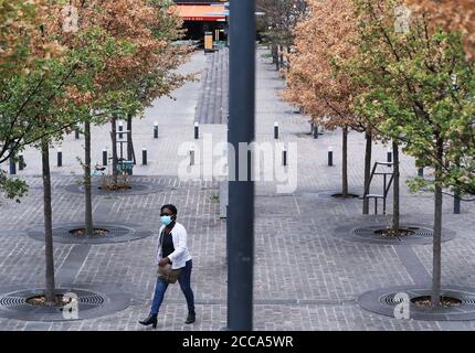 Paris, France. 20 août 2020. Une femme portant un masque est vue dans le quartier d'affaires de la Défense près de Paris, France, le 20 août 2020. Les travailleurs français devraient porter des masques dans tous les lieux de travail collectifs dans le cadre d'un plan gouvernemental visant à contenir un rebond alarmant des infections à coronavirus, a annoncé mardi la ministre du travail Elisabeth borne. Credit: Gao Jing/Xinhua/Alamy Live News Banque D'Images