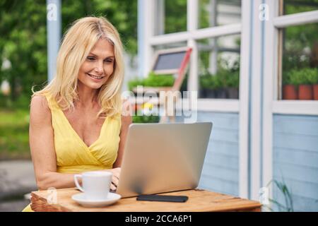 Une dame ravie de regarder l'écran de l'ordinateur Banque D'Images