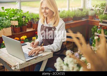 Femme souriante travaillant dans un bureau en bois Banque D'Images