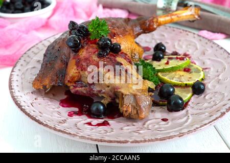 Cuisse de canard cuite confit avec sauce aux baies sur une assiette. Menu vacances. Banque D'Images