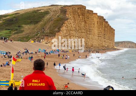 Un gardien de la vie regardant la plage et les falaises de West Bay Dorset, pendant l'été 2020 Banque D'Images