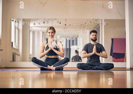 Femme pratiquant le yoga avec son instructeur masculin Banque D'Images