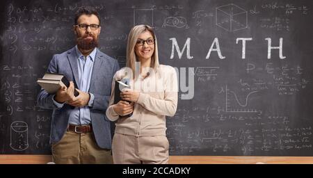 Professeur de mathématiques homme et femme devant un tableau noir avec texte et formules Banque D'Images