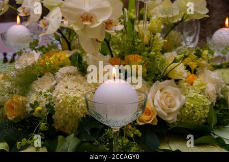 Table décorée avec des compositions de table et des bougies allumées, vert, blanc Banque D'Images