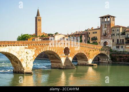 Le pont romain Ponte Pietra en pierre sur la rivière Adige dans la vieille ville de Vérone est éclairé le soir au soleil, Vénétie, Italie Banque D'Images