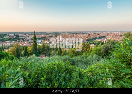 Vue sur les buissons verts du sanctuaire de notre-Dame de Lourdes au lever du soleil sur la vieille ville de Vérone, Italie Banque D'Images