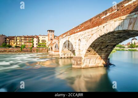 Le pont romain Ponte Pietra en pierre au-dessus de la rivière Adige avec le panorama de la vieille ville de Vérone au soleil du matin, Vénétie, Italie Banque D'Images