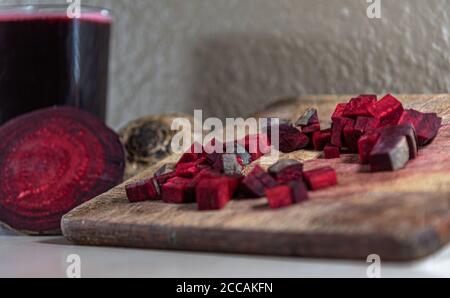 Betterave (Beta vulgaris L.) hachée sur une planche de bois à côté de tubercules cassés. Légumes pour salades. Légumes utilisés dans la cuisine brésilienne. Source de sucre pr Banque D'Images