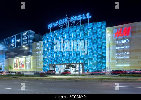 Kiev, Ukraine - 08 août 2020: Centre commercial sur le remblai du fleuve Dniepr. La photo a été prise tard dans la soirée sur fond de lanternes lumineuses et d'un ciel sombre. Éditorial. Banque D'Images