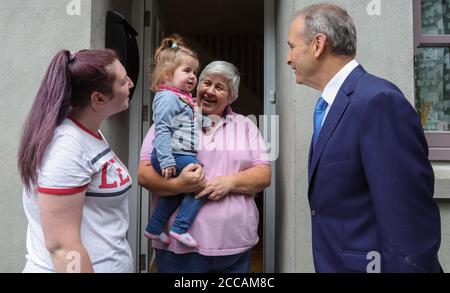 Un Taoiseach Micheal Martin discute avec les habitants locaux avec le petit bébé Mia Thornton lorsqu'il visite les maisons et les entreprises endommagées par les inondations de Skibbereen le matin après une inondation a causé des dommages importants à un certain nombre de locaux dans la populaire ville touristique irlandaise. Banque D'Images