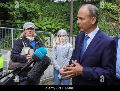 Un Taoiseach Micheal Martin discute avec les habitants locaux avec le petit bébé Mia Thornton lorsqu'il visite les maisons et les entreprises endommagées par les inondations de Skibbereen le matin après une inondation a causé des dommages importants à un certain nombre de locaux dans la populaire ville touristique irlandaise. Banque D'Images