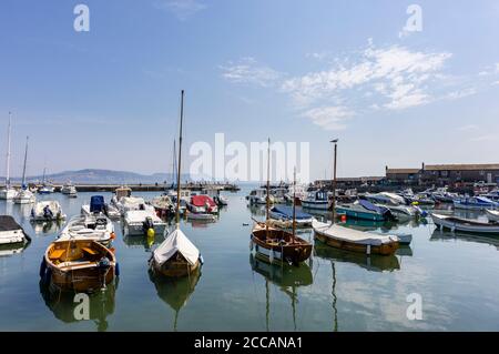 Voiliers et bateaux à moteur amarrés à la Cobb à Lyme Regis, une station balnéaire populaire sur la côte jurassique à Dorset, au sud-ouest de l'Angleterre Banque D'Images