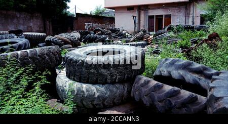 DISTRICT KATNI, INDE - 03 AOÛT 2019 : grosse pile de pneus d'automobile sur l'usine en panne. De nombreux pneus en caoutchouc noir sur le sol à l'intérieur de l'ancien h Banque D'Images