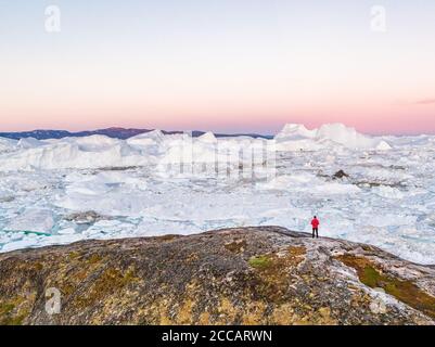 Paysage de la nature du Groenland paysage au coucher du soleil avec randonnée voyage randonnée touristique marche appréciant la vue de glace gelée dans la mer d'océan. Aventure arctique dans le Banque D'Images