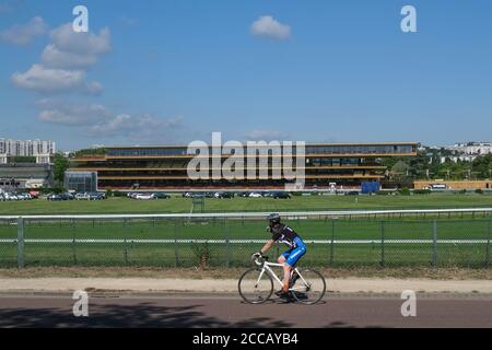 Cycliste passant devant l'hippodrome de Longchamp à Paris, France, Europe. Banque D'Images