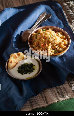 Petit-déjeuner indien du sud Savoury semolina porridge rava Upma avec chutney à la menthe verte et paratha.authentique nourriture végétarienne encore vie. Banque D'Images