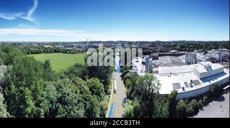 parc public et domaine industriel avec canal la division entre les deux dans la ville de banbury oxfordshire angleterre Banque D'Images