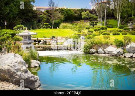 Jardin japonais avec lanterne en pierre et reflets dans l'étang de la Serena, au Chili Banque D'Images