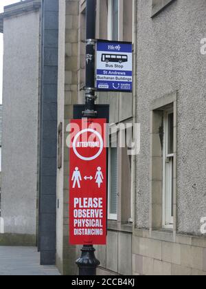 Guidage du coronavirus sur un arrêt d'autobus à l'extérieur d'un édifice universitaire à St Andrews : veuillez observer la distance physique. Banque D'Images