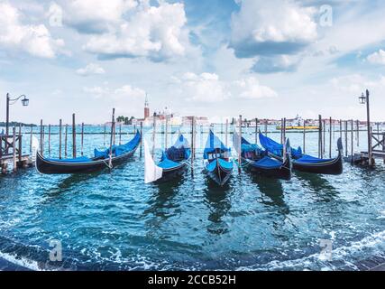 Paysage coloré avec ciel bleu clair sur la piazza San Marco à Venise. Rangée de gondoles garées sur le quai de la ville. Église de San Giorgio Maggiore en arrière-plan, Italie, Europe Banque D'Images