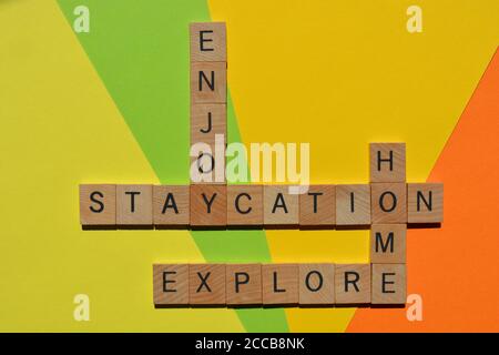 Staycation, Explore, Home, Ajouy, mots en lettres de l'alphabet en bois en forme de mots croisés Banque D'Images