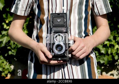 Rolleiflex double reflex moyen format vintage caméra devant une chemise à rayures Banque D'Images