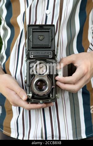Rolleiflex double reflex moyen format vintage caméra devant une chemise à rayures Banque D'Images
