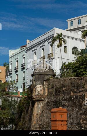 Une ancienne boîte de sentry espagnole sur le mur de la ville du vieux San Juan, Porto Rico avec une architecture plus moderne derrière. Banque D'Images