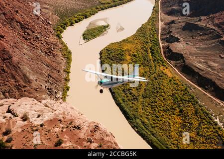 Un Cessna 180 Skywagon de l'Utah Backcountry Pilots Association survole la rivière Green à Labyrinth Canyon près de Moab, Utah. Banque D'Images