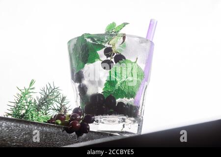 cocktail de baies, menthe, glace dans un rox verre sur le bord d'un comptoir de bar fond blanc. vue bot, gros plan, orientation horizontale Banque D'Images