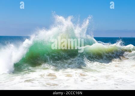 Jet d'eau blanche et sable étant tiré du fond par une vague de rupture aux célèbres bouteilles de surf. Newport Beach, Californie ; États-Unis Banque D'Images