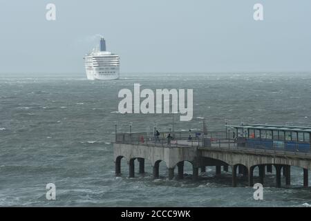 Storm Ellen batte la côte sud de l'Angleterre au plus fort de la saison des fêtes d'été avec des rafales de vent allant jusqu'à 60 km/h et une marée haute. Un bateau de croisière est ancré au large de la côte au-delà de la jetée en raison du coronavirus, Boscombe, Bournemouth, Dorset, Royaume-Uni, 21 août 2020 Banque D'Images