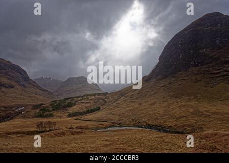 La rivière Etive qui traverse le Glen entre les montagnes Des Highlands écossais par une journée humide en avril avec un ciel sombre spectaculaire» Banque D'Images