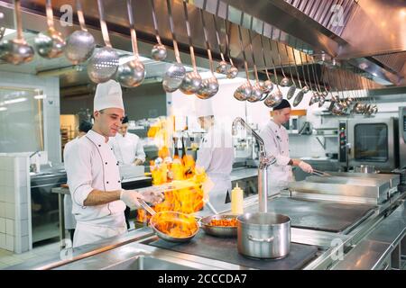 Cuisine moderne. Les cuisiniers préparent les repas sur la cuisinière dans la cuisine du restaurant ou hôtel. L'incendie dans la cuisine. Banque D'Images