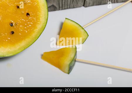 Morceaux de pastèque jaune sur bâtons. Banque D'Images