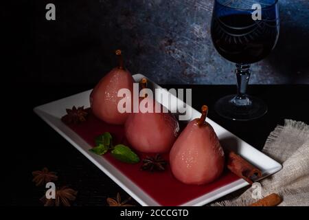 Poires pochées au vin rouge avec cannelle et anis. Banque D'Images