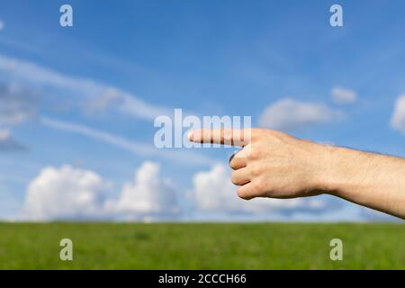 Main d'homme montrer le numéro un sur l'arrière-plan de la nature, points doigt Banque D'Images