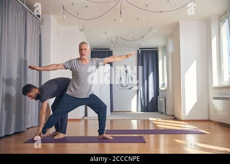 Débutant yogi pratiquant le yoga dans une salle de gym Banque D'Images