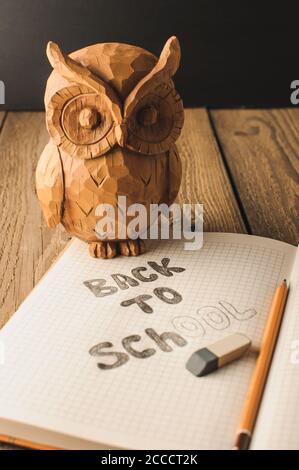 Retour à l'école, la notion de parent. Owl sur une table en bois. L'inscription sur la craie de couleur ardoise. Fournitures scolaires, rustique. Banque D'Images