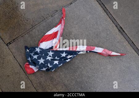 Après une douche à effet pluie, un bandana drapeau américain Stars and Stripes se trouve sur la chaussée mouillée de la City de Londres, le quartier financier de la capitale britannique, le 17 août 2020, dans la City de Londres, en Angleterre. Banque D'Images