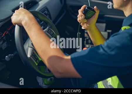 Homme utilisant un talkie-walkie dans sa voiture Banque D'Images