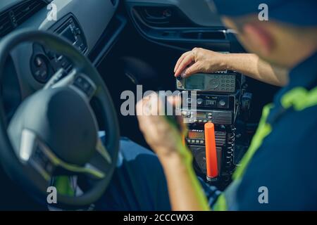 Homme en vêtement de travail assis dans une voiture Banque D'Images