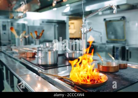 Cuisine moderne. Les cuisiniers préparent les repas sur la cuisinière dans la cuisine du restaurant ou hôtel. L'incendie dans la cuisine. Banque D'Images
