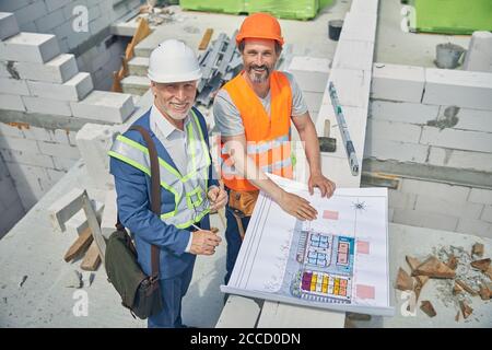 Homme de tête joyeux et un constructeur regardant vers le haut Banque D'Images
