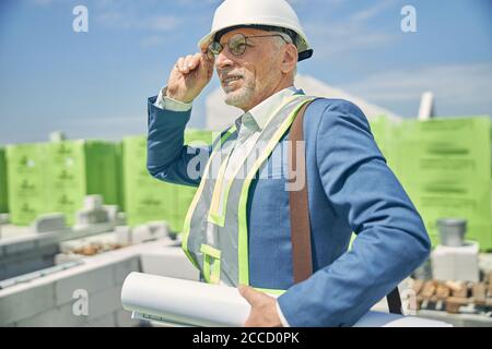 Ingénieur civil tenant des plans dans sa main Banque D'Images