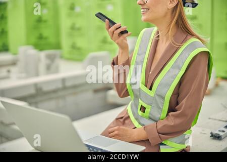 Femme ingénieur dans un casque de protection parlant au téléphone Banque D'Images